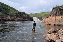 Salmon angler fly fishing in Falls Pool on the Eastern Litza River. Kola Peninsula, Northwest Russia, 2005.