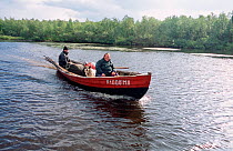Sami Woman and son returning to Lovozero by boat after summer fishing trip. Kola Peninsula, Northwest Russia, 2005.