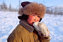 Even boy enjoying ice cream at -35 Celsius. Northern Evensk, Magadan Region, Eastern Siberia, Russia, 2006.