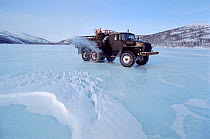 Ural truck on winter road across the frozen Russian Amalone River. North Evensk, Magadan Region, Eastern Siberia, Russia, 2006.