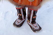 Koryak woman wearing traditional Reindeer skin boots decorated with bead work. Evensk, Magadan, Eastern Siberia, Russia, 2006.