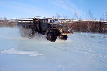Truck travelling through water on road on surface of the frozen Garmanda River. Evensk, Magadan Region, Eastern Siberia, Russia, 2006.