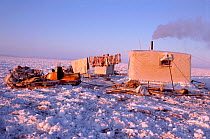 Dolgan reindeer / caribou herder's balok (wooden hut built on sled runners) with chimney smoking. Taymyr, Northern Siberia, Russia, 2004.