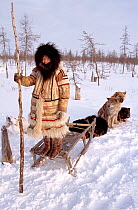 Nganasan girl standing on sled with Huskies (Canis familiaris) near the Kheta River. Taymyr, Northern Siberia, Russia, 2004.