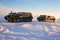 Vezdekhods (track vehicles) travelling across tundra on a winter road near Tiksi. Northern Yakutia, Siberia, Russia, 2001.