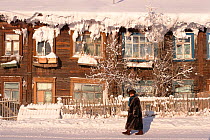 Woman walking along street in the town of Yakutsk during winter. Yakutia, Siberia, Russia, 2001.