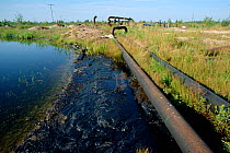 Oil spilling from pipes and polluting lake near Niznevartovsk, Khanty Mansiysk, Western Siberia, Russia, 2000.