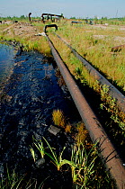 Oil spilling from pipes and polluting lake near Niznevartovsk, Khanty Mansiysk, Western Siberia, Russia, 2000.