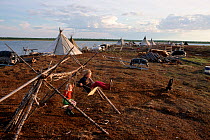 Nenets children playing on home made swing at summer camp near Nadym. Yamal, Western Siberia, Russia, 2000.