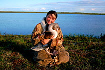 Nenets girl with pet Swan cygnet, probably Whistling swan (Cynus columbianus). Nadym Tundra, Yamal, Western Siberia, Russia, 2000.