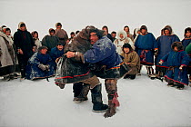 Nenets men watching a round of wrestling during local festival. Yamal, Siberia, Russia, 1993.