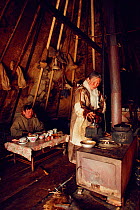 Nenets woman making tea on a stove inside tent. Yamal, Siberia, Russia, 1993.
