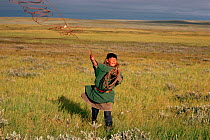 Nenets boy practising throwing his lasso. Yamal, Western Siberia, Russia, 1993.