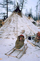 Nenets baby in a cradle on wooden sled at Reindeer / Caribou herders' winter camp. Yamal, Western Siberia, Russia, 1996.