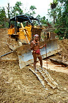 A Mentawai medicine man standing on broken bulldozer in his rainforest. Siberut Island, Indonesia, 1993.