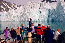 Tourists watching as icebreaker approaches a glacier in Magdalene Fjord, Spitsbergen, Norway, 1993.