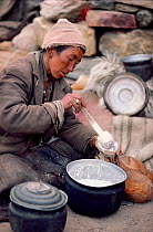 Woman ladling Yak milk into a skin. Nimaling Plateau, Ladakh, India, 1986.