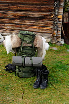 Rucksack and walking boots for camping expedition outside wooden building, Forollhogna National Park, Norway, September 2008