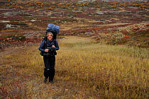 Laurent Joffrion walking carrying large rucksack, Forollhogna National Park, Norway, September 2008