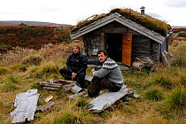 Photographer, Vincent Munier, and Laurent Joffrion outside small hut, Forollhogna National Park, Norway, September 2008