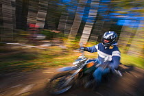 A man riding his motorbike through the forest, Jericho Mountain State Park, White Mountains, Berlin, New Hampshire, USA. September 2009