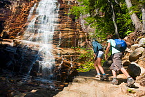 Two people hiking at Arethusa Falls, Crawford Notch State Park, White Mountains, New Hampshire, USA. August 2009