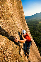 A man rock climbing near the top of Cathedral Ledge. Echo Lake State Park, White Mountains, in North Conway, New Hampshire, USA. October 2009, Model released