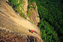 A man climbs "Top of the Prow" rock on Cathedral Ledge. Echo Lake State Park, White Mountains, in North Conway, New Hampshire, USA. October 2009, Model released