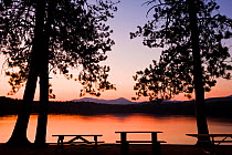 Picnic benches silouetted after sunset at White Lake State Park in Tamworth, New Hampshire, USA. October 2009