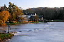 River Avon in spate flowing over Bathampton weir and past Bathampton Mill pub, near Bath, Somerset, UK. November 2009
