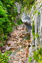 Tourists canyoning down Rio Aragon Subordan through the Boca del Infierno (Hell's Mouth) gorge, carved by river action through karst limestone rock. Hecho valley, Spanish Pyrenees, Huesca, Aragon, Spa...