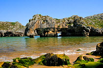 Cuevas del mar (Sea caves) beach with arches carved by the sea through karst limestone rocks. Near Llanes, Asturias, Spain. July 2009 Blue Flag Beach.