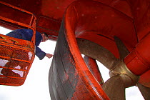 Engineer carrying out hull repairs on a fishing vessel in dry dock, Skagen, Denmark. March 2010, model released.