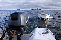 Outboard motorboat (Orkney Longliner) towing tender off Arthur, Eastern Isles, Isles of Scilly, UK,