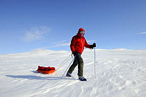 Winter hiker pulling his pulka on Banks island, North West Territories, Canada, April 2010