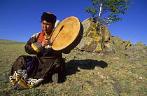 Buriat shaman plays tambourine on Olkhon Island, Baikal lake, Siberia, Russia, June 2000