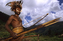 Portrait of Yali hunter in traditional dress, with nose adornment made of wild pig's bones, rooster feather head-dress, penis case, bow and arrows. West Papua, former Irian-Jaya, Indonesia, August 200...
