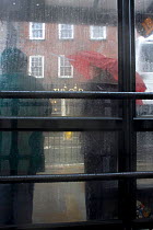 Sheltering in the bus stop during rainstorm. Example of impact of climate change on ordinary people. Denbigh, North Wales, UK. July 2009.