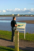 Tourists / local resident enjoying views of the Severn Estuary. England, August 2009