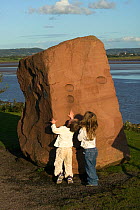 Children examining rock feature on banks of the Severn Estuary. England, August 2009