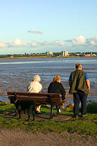 Tourists / local residents enjoying views of the Severn Estuary. Berkeley nuclear power station in background. England, August 2009