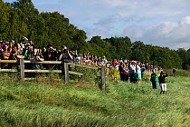 Spectators line up to watch surfers on Severn bore. Severn Estuary. England, August 2009