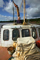 Portrait of Fred Larkham (Gloucestershire boatman) on board their working boat in the Severn Estuary. England , August 2009
