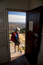 Person with rucksack viewed through doorway of Atascosa Lookout in the Tumacacori Mountains of the Coronado National Forest, Arizona, USA, March 2009, model released