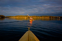Kayakers in a bydarka style boats exploring the waters of Wescott Bay San Juan Island. Washington, USA, May 2009