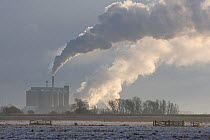 Cantley sugar beet factory with smoke belching from its chimneys, in snow, Norfolk, UK. December 2009