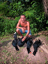 Hunter showing dead Razor-billed Curassows (Mitu tuberosum) that he killed in the Amazon Upland Rainforest in Arum community, Piagacu-Purus Sustainable Development Reserve, Purus River, Amazonas State...