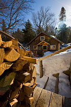 Split logs outside a wooden cabin at Little Lyford Pond Camps near Greenville, Maine, USA, March 2009.