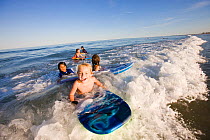 Children on boogie boards in surf at Hampton Beach, New Hampshire, USA, August 2008. Model released.