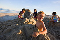 Children playing in sand on Hampton Beach, New Hampshire, USA, August 2008. Model released.